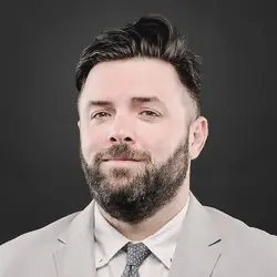 A man with a beard and suit jacket